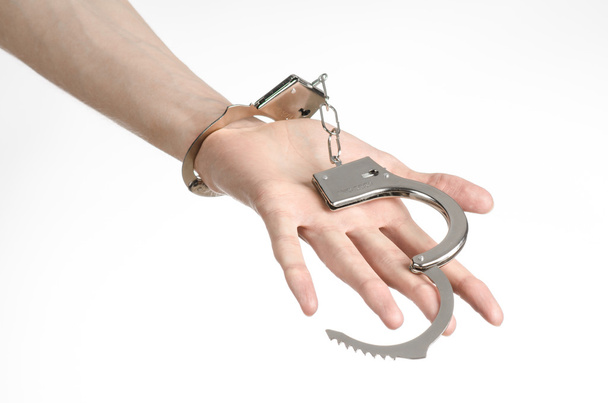 Тюрьма и осужденная тема: руки человека с наручниками изолированы на белом фоне в студии, надеть наручники на убийцу
 - Фото, изображение