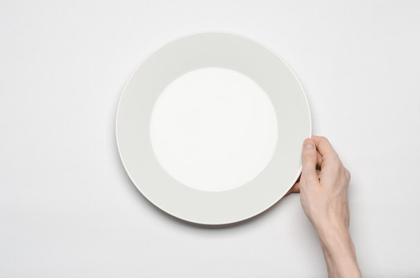 Restaurant and Food theme: the human hand show gesture on an empty white plate on a white background in studio isolated top view - Fotoğraf, Görsel