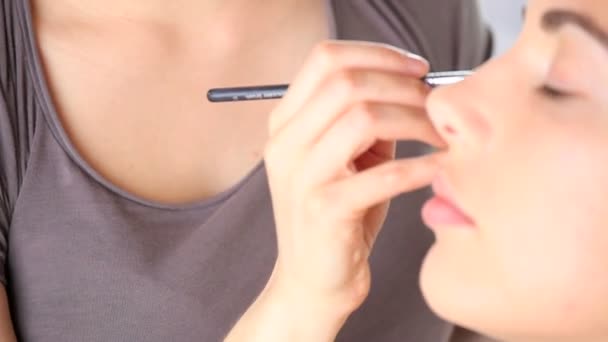 makeup artist applying eyeshadow on eyelid using makeup brush - Footage, Video