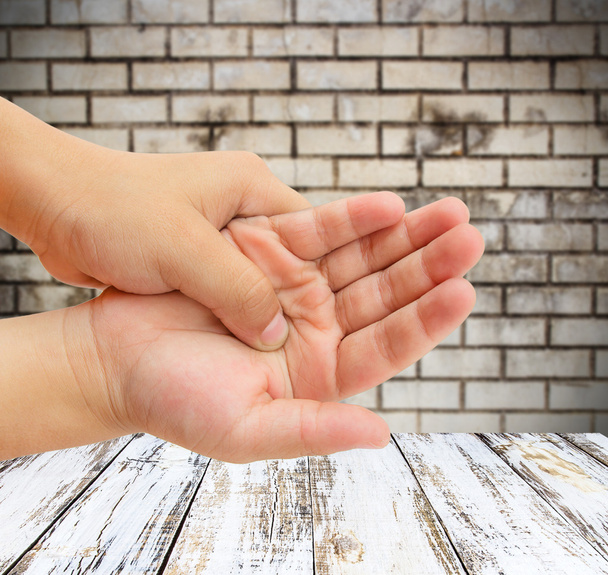 hand pain with blurred brick wall background - Photo, Image