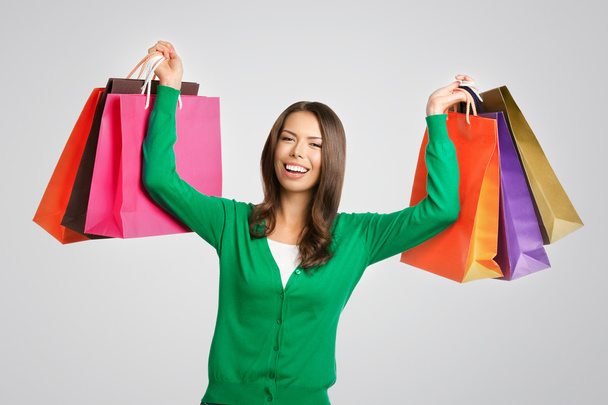 Young happy woman with shopping bags, over grey - Photo, Image