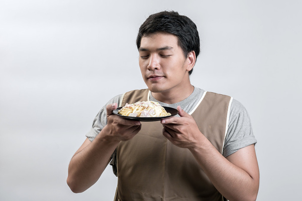 Asiatique homme dans tablier avec spaghetti carbonara
 - Photo, image