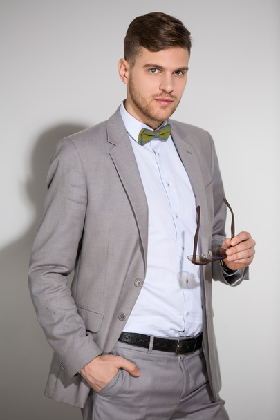 Attractive man in a suit and tie butterfly dress stylish sunglas - Zdjęcie, obraz