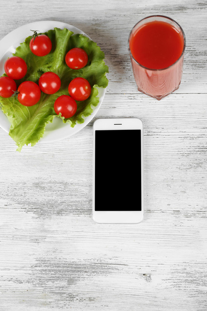 Food and mobile phone on wooden background - Zdjęcie, obraz