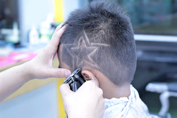 Strzyżenie chłopca z clipper i brzytwa w sklepie fryzjer - Zdjęcie, obraz