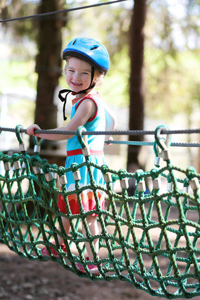 Valiente niña jugando en el parque de aventuras
 - Foto, Imagen