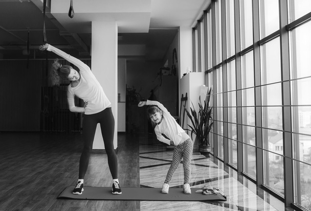 Twee meisjes van verschillende leeftijden maken van yoga - Foto, afbeelding