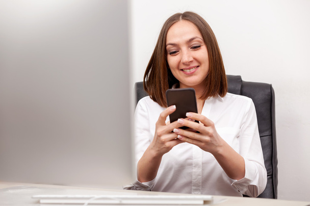 Businneswoman is writing an email from her mobile phone - Фото, зображення