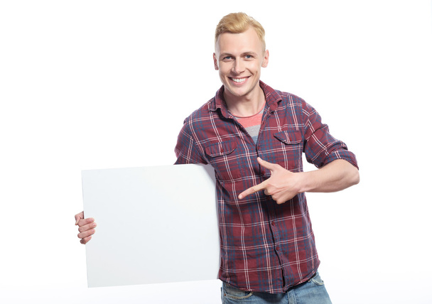 Smiling young man holding white sheet of paper  - Фото, зображення