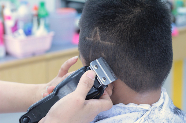 Strzyżenie chłopca z clipper i brzytwa w sklepie fryzjer - Zdjęcie, obraz