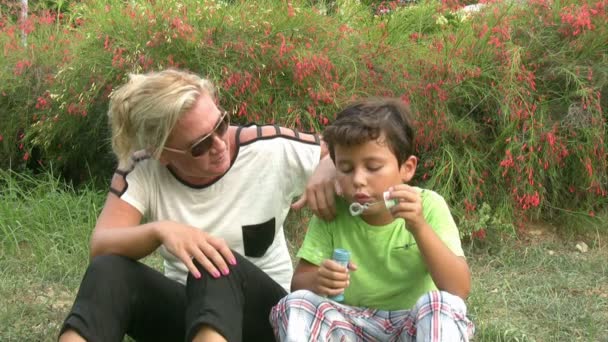 Μητέρα και γιος φυσώντας φυσαλίδες - Πλάνα, βίντεο