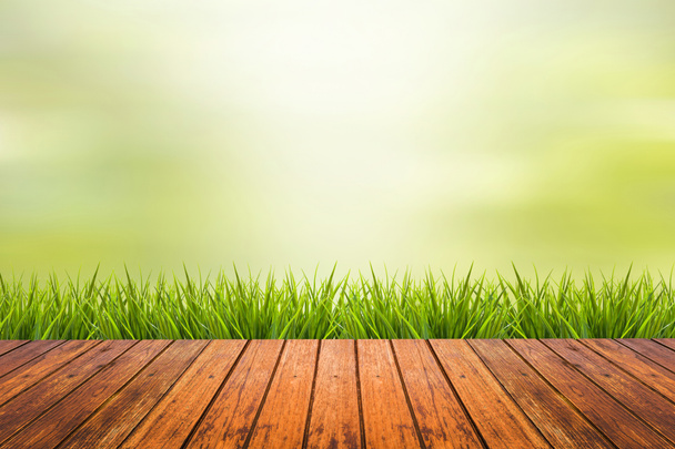 трава з зеленим розмитим фоном і дерев'яною підлогою
 - Фото, зображення