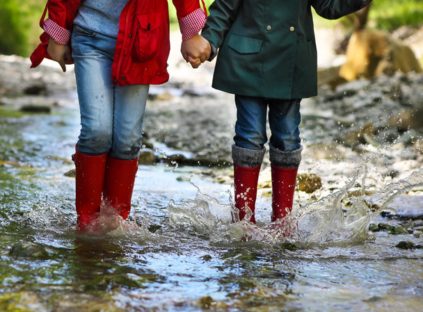 Enfant portant des bottes de pluie sautant. Gros plan
 - Photo, image