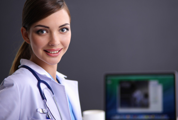 Female doctor working sitting on gray  background - Valokuva, kuva