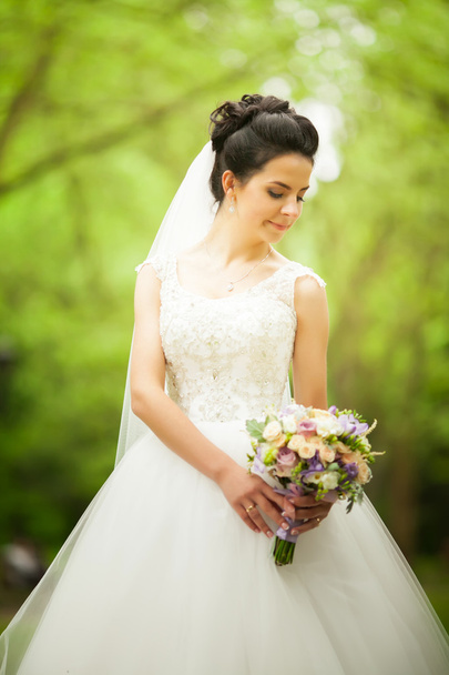 Beautiful bride outdoors in a forest - Φωτογραφία, εικόνα