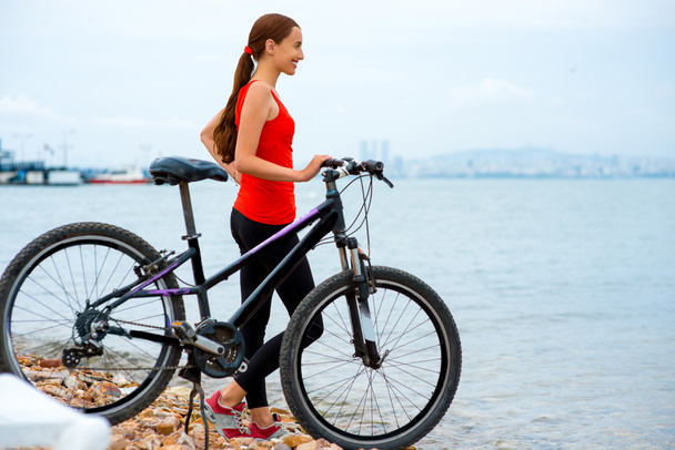 Woman with bicycle on the beach - Photo, Image