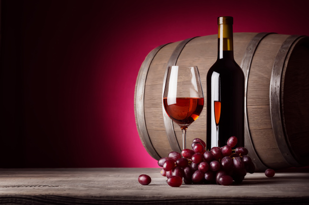 Бокал красного вина с бутылкой и виноградом
 - Фото, изображение