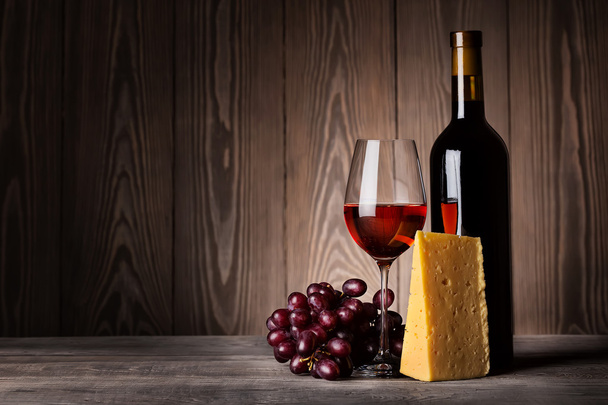 Glass of red wine with grapes and cheese - Фото, изображение