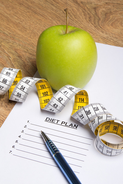 close-up de papel com o plano de dieta, caneta, apple e medida amarela  - Foto, Imagem