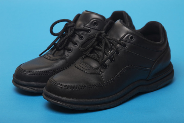 черные ботинки изолированы на синем фоне
 - Фото, изображение