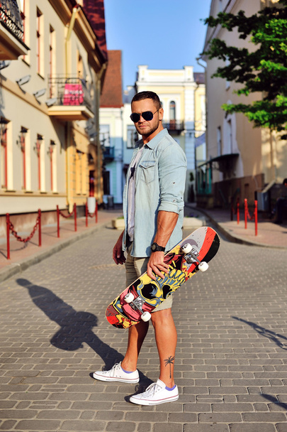Hipster stylu młodego człowieka z deskorolka - Zdjęcie, obraz