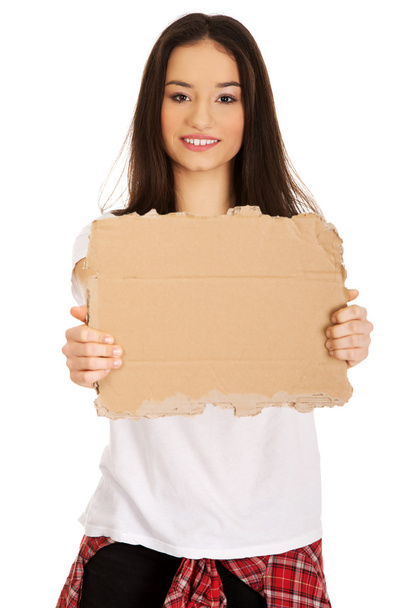 Young woman holding a cardboard. - Foto, imagen
