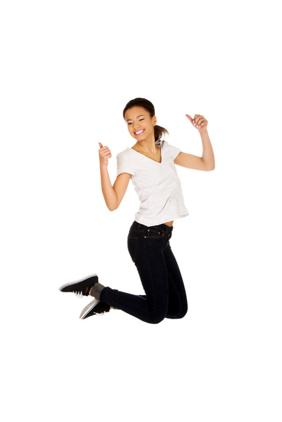 Happy woman jumping with thumbs up. - Photo, image