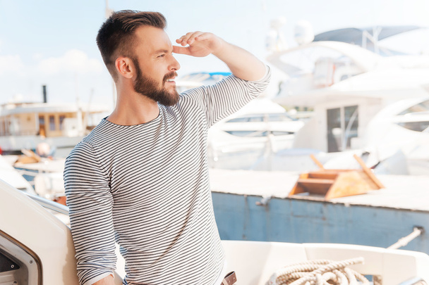 young man standing on board of yacht - Valokuva, kuva