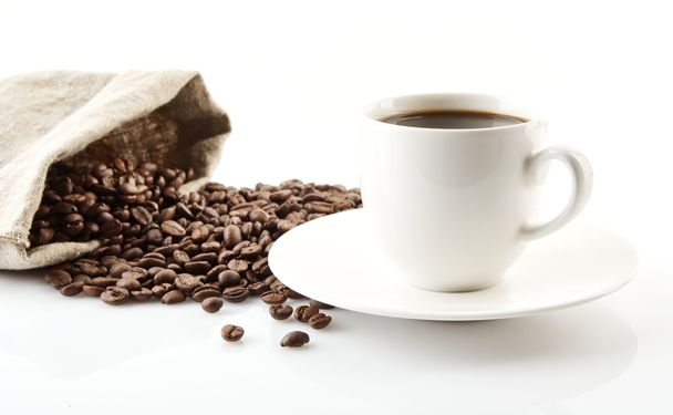 Taza de café con platillo con bolsa con granos de café en blanco
 - Foto, imagen