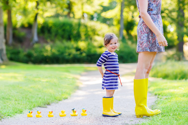 matka i urocze dziecko w żółty gumowe buty - Zdjęcie, obraz