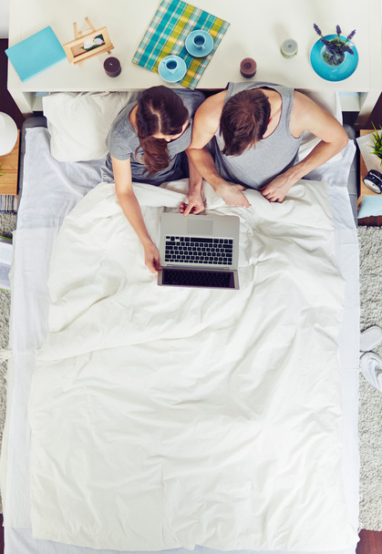 couple networking on laptop in bed - Photo, Image