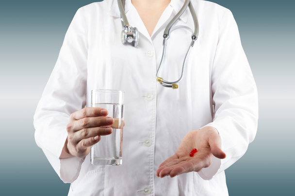 Female doctor's hand holding glass of water, giving pills. Close - Fotoğraf, Görsel