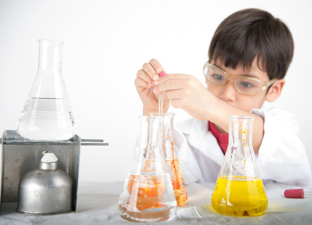 Маленький хлопчик вчиться в хімічній науці в класі
 - Фото, зображення