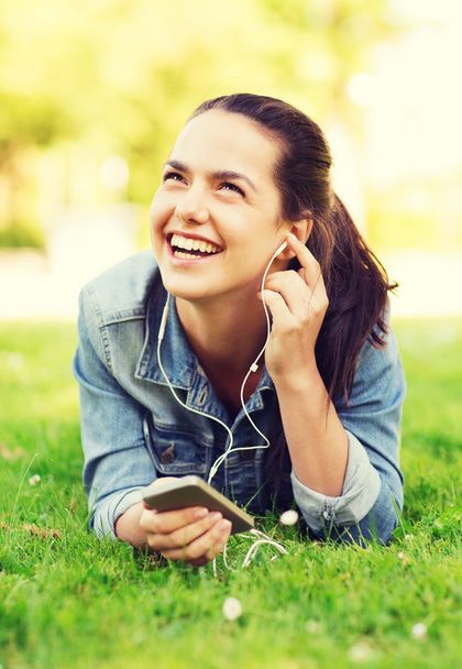 laughing young girl with smartphone and earphones - 写真・画像