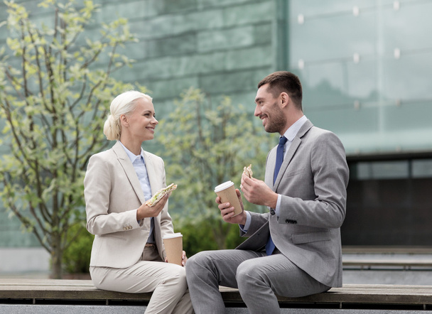 smiling businessmen with paper cups outdoors - Foto, Imagem