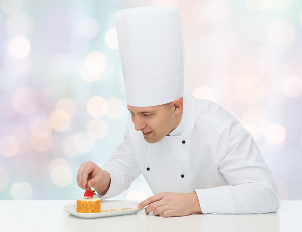 happy male chef cook decorating dessert - Fotó, kép