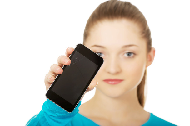 Teen woman with a broken cell phone. - Φωτογραφία, εικόνα