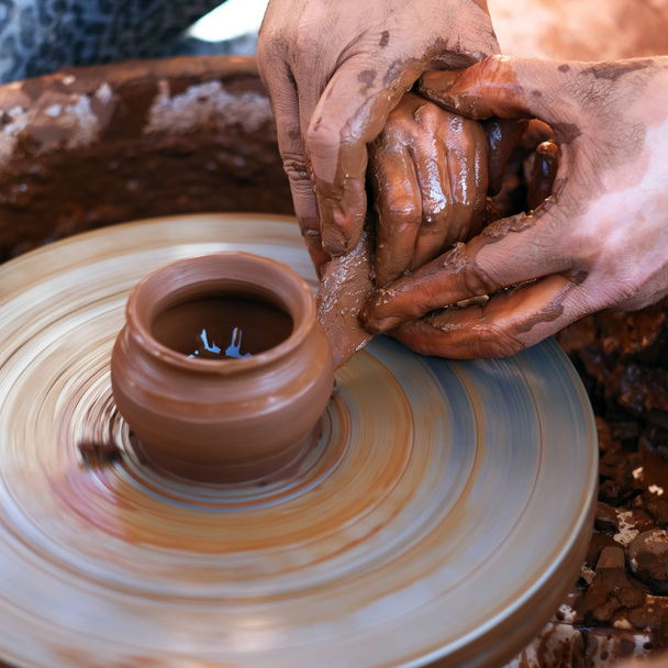 Manos trabajando en la rueda de cerámica
 - Foto, imagen