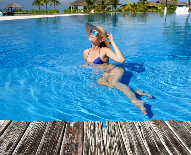 Vrouw ontspannen aan het zwembad - Foto, afbeelding