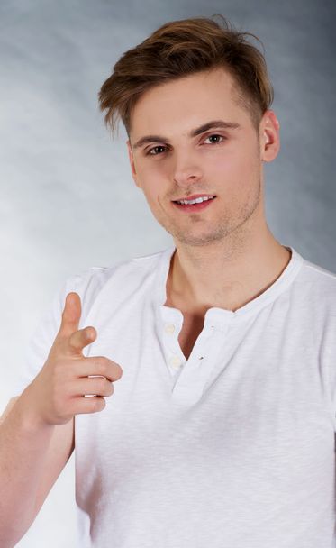 Handsome young man pointing towards camera. - Foto, Bild