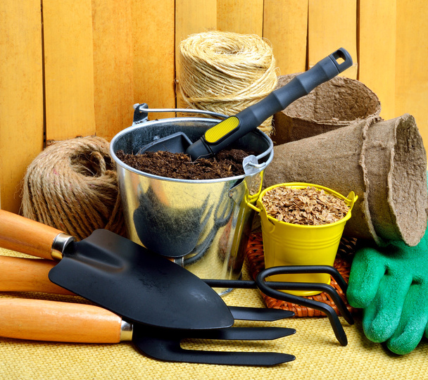 Gardening tools, peat cups, thread, seeds in tins against fence - Fotó, kép