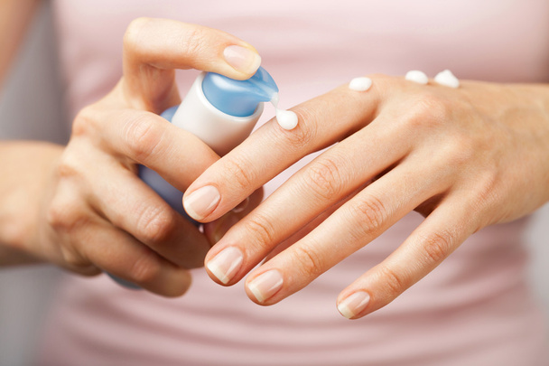 Woman applying cream on hands - Foto, afbeelding