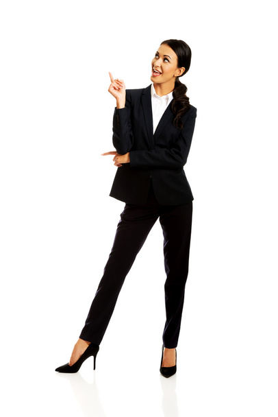 Businesswoman pointing at copyspace - Foto, afbeelding
