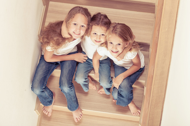 Портрет счастливых детей, которые сидят на лестнице в й
 - Фото, изображение