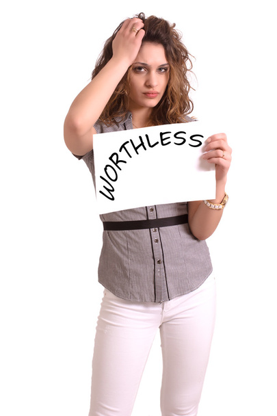 uncomfortable woman holding paper with Worthless text - Φωτογραφία, εικόνα