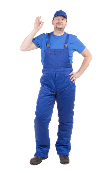 Man in blue overalls shows ok sign. - 写真・画像