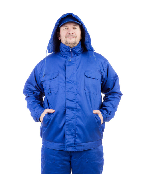 Worker in blue coat and hat.  - 写真・画像