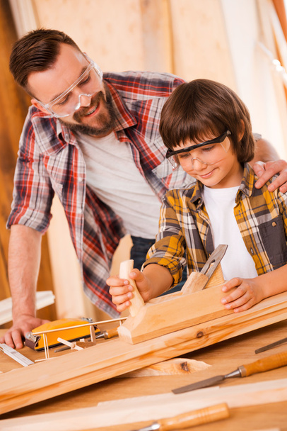 carpenter embracing his son in workshop - Foto, afbeelding