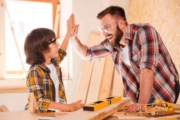 carpenter and son giving high-five - Foto, imagen