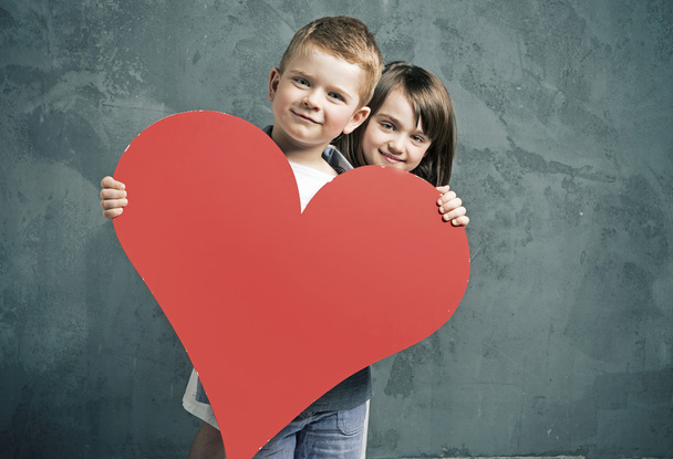 Boy and girl holding a toy heart - Foto, imagen